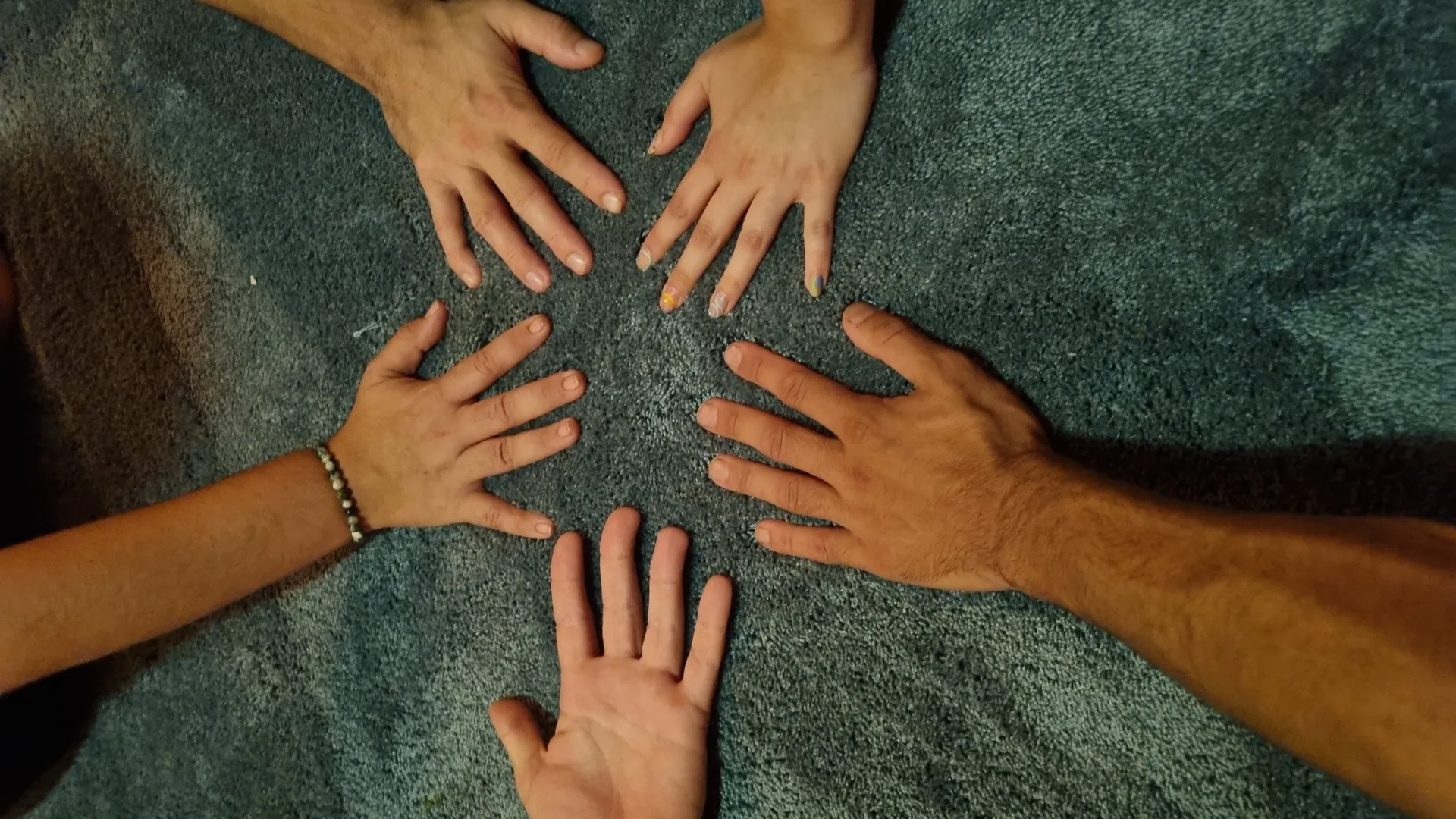 Cinq mains en cercle lors d'un atelier Tendresse.